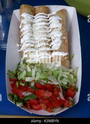 Three Flautas topped with sour cream and cheese Stock Photo