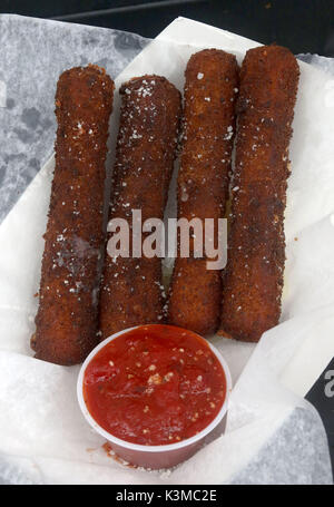 Oversized fresh breaded mozzarella sticks sprinkled with romano cheese and red sauce Stock Photo