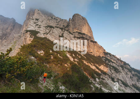 Europe, North Italy, Veneto, Belluno, Monti del Sole, Dolomites. Man looking at the first light on the north face of Piz de Mezodi. Stock Photo