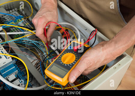 Close-up Of A Electrician Checking Fuse Box With Multimeter Stock Photo
