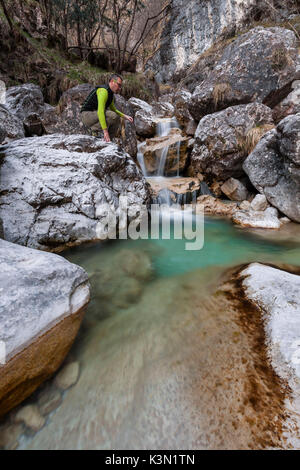 Hiker looking at the small waterfalls of turquoise water in val Salet, Monti del Sole, National park Belluno Dolomites, Italy Stock Photo