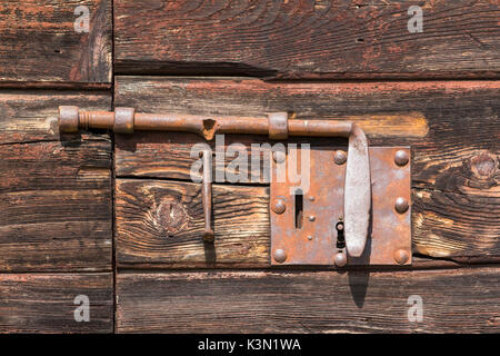 Old lock or latch on wooden door, typically used once in huts or barns of the dolomites. Stock Photo