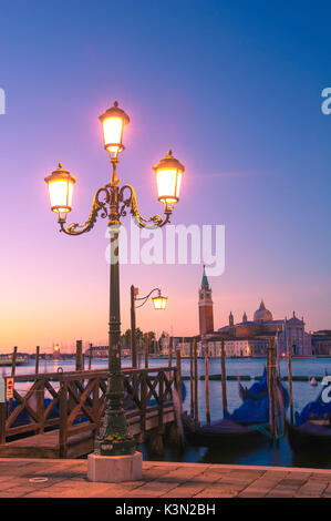 Riva degli Schiavoni, Venice, Veneto, Italy. Moored gondolas in front of St George's church. Stock Photo