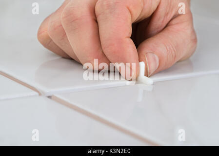 Close-up Of A Person's Hand Placing Spacers Between Ceramic Floor Tiles Stock Photo