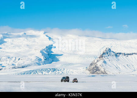 East Iceland, Iceland. Big off-road cars parked in the snow and snow capped mountains in winter. Stock Photo