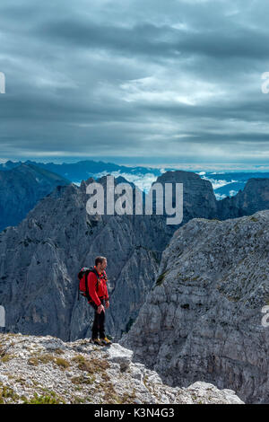 Pizzon, Monti del Sole, Dolomites, Veneto, Italy. Mountaineer on the summit of Pizzon. In the background the Monti del Sole Stock Photo