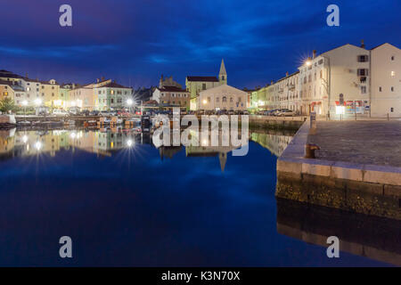 Europe, Slovenia, Primorska, Izola. Old town and the harbour with fishing boats at night Stock Photo