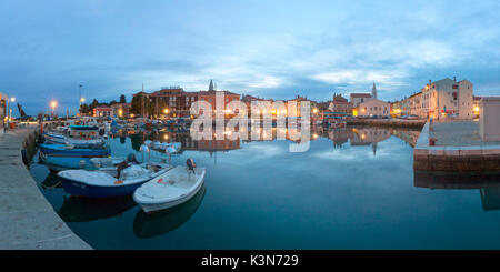 Europe, Slovenia, Primorska, Izola. Old town and the harbour with fishing boats at dusk Stock Photo