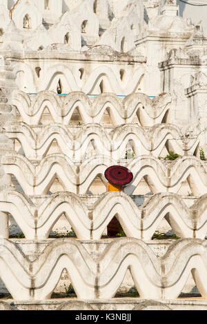 Mingun, Sagaing region, Myanmar (Burma). Woman with red umbrella in the middle of the white terraces of the Hsinbyume white pagoda. Stock Photo