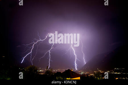 A strong thunderstorm discharge many lightning on the Meran city, during the night. Passiria Valley, Trentino Alto Adige, Italy Stock Photo