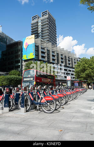 Santander docking station on Hampstead road overlooked by Gary Hume's 'Pecking Bird' artwork. Stock Photo