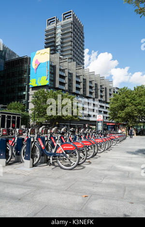 Santander docking station on Hampstead road overlooked by Gary Hume's 'Pecking Bird' artwork. Stock Photo