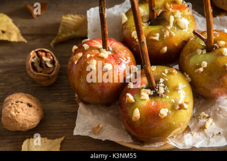 Homemade Caramel Apples on a Stick for Halloween. Organic Snack - Caramel Apples with Walnuts. Stock Photo