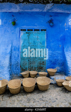 Baskets on front of a blue building in Chefchaouen Stock Photo