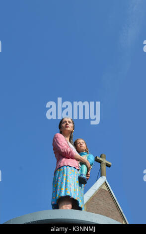 'Säulenheiligen' (Stylites) is an art project of Christoph Pöggeler in Düsseldorf placing life-size polyester figures of people on advertising pillars Stock Photo