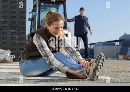 female builder putting working shoes on Stock Photo