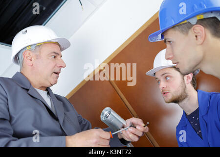 young technicians learning to installing camera in building corner Stock Photo