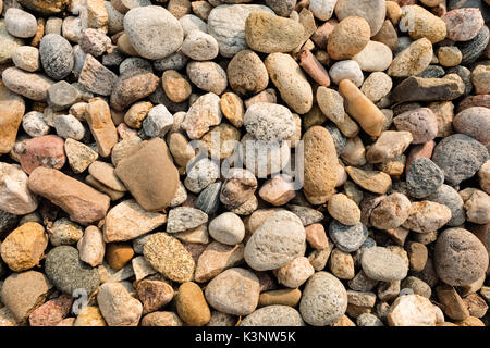 Close up of rounded and polished beach rocks background Stock Photo