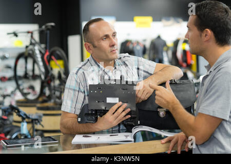 man asking seller for help in sport bike shop Stock Photo