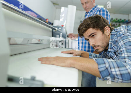 man using paper press machine in factory Stock Photo