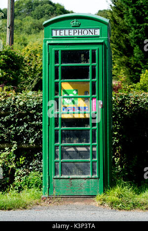 Green converted defibrillator and first aid telephone box, Berrow Green, Worcestershire, England, UK Stock Photo