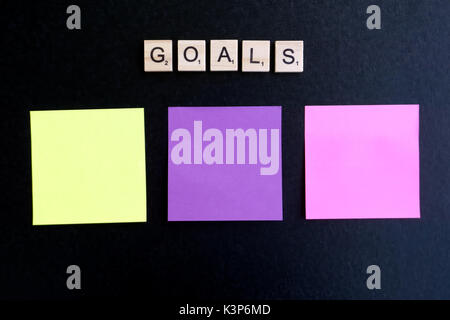 Goals words on wood blocks and three multi colored paper on black background Stock Photo