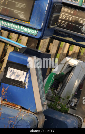 redundant petrol pumps disused at a derelict garage no longer selling petrol or diesel fuels of the future gasoline derv out of use rusty fuel petrol Stock Photo