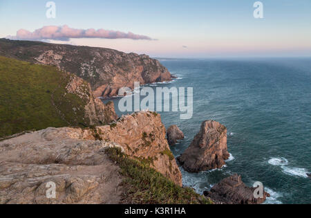 Ocean waves crashing on the cliffs of the Cabo da Roca cape at sunset Sintra Portugal Europe
