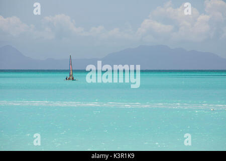 A catamaran in the crystalline waters of the Caribbean Sea Jolly Beach Antigua and Barbuda Leeward Island West Indies Stock Photo