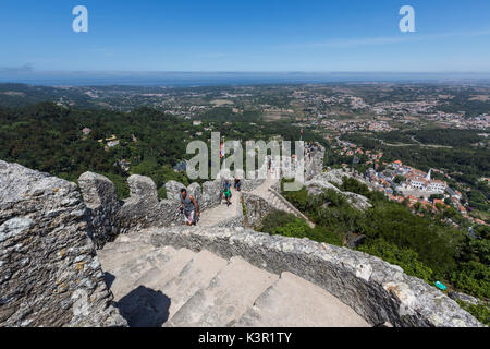 Tourists proceed on fortified stone path of the ancient Castelo dos Mouros Sintra municipality Lisbon district Portugal Europe Stock Photo