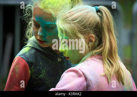 Colorful faces of two teenagers during the holi festival of colors. Cieszyn, Poland. Stock Photo