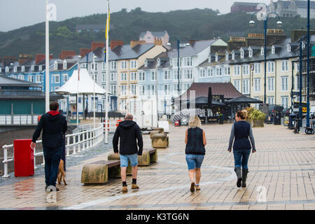 Aberystwyth Wales UK, Monday 04 September 2017 UK Weather: People out walking along the almost deserted promenade on a dull, misty and humid morning, with drizzle and rain in Aberystwyth Wales photo Credit: Keith Morris/Alamy Live News Stock Photo