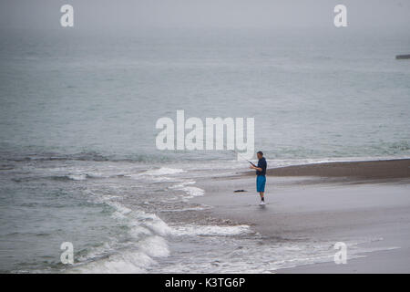 Aberystwyth Wales UK, Monday 04 September 2017 UK Weather: A man fishing on the deserted beach on a dull, misty and humid morning, with drizzle and rain in Aberystwyth Wales photo Credit: Keith Morris/Alamy Live News Stock Photo