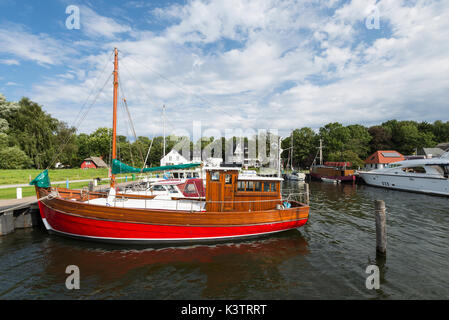 Fischerboot aus Holz mit rotem Rumpf im Hafen von Kloster auf der Insel Hiddensee in der Morgensonne, Mecklenburg-Vorpommern, Deutschland Stock Photo