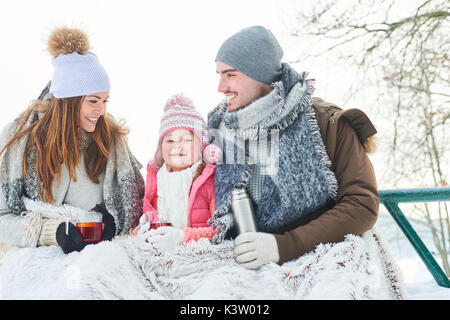 Happy family drinking tea during winter trip in the nature Stock Photo