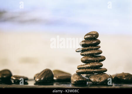 Zen stones stacked on abstract beach background Stock Photo