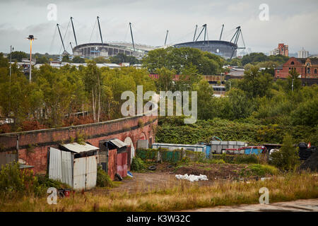 Trees growing on the abandoned closed elevated railway arches Blind Lane curve L&YR Ardwick branch, with Manchester City Etihad Stadium near Piccadill Stock Photo