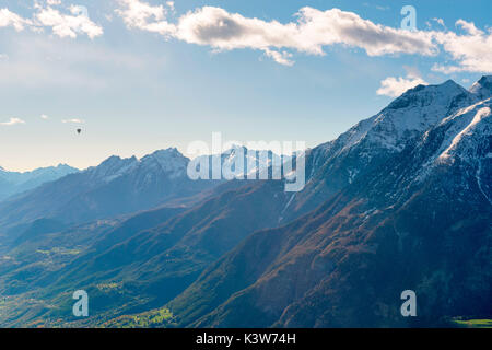 hot air balloon flies over Aosta city, Valle d'Aosta, Italy, Europe. Stock Photo
