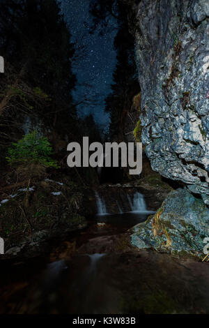 Starry night over Koflertal waterfall in winter, Non Valley, Trentino Alto Adige, Italy Stock Photo