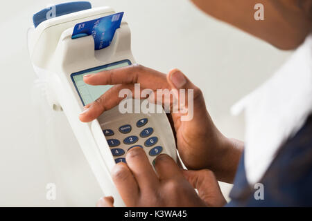 Close-up Of Person's Hand Using Credit Card Machine Stock Photo