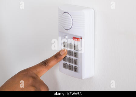 Close-up Of Person's Hand Pressing Button On Security System Stock Photo