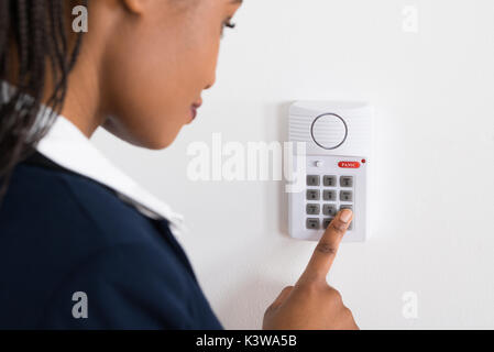 Close-up Of A Young African Businesswoman Pressing Button On Security System Stock Photo