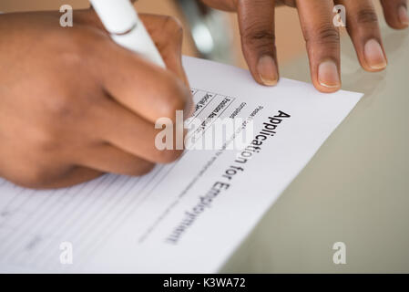 Close-up Of A Woman Filling Employment Form Stock Photo