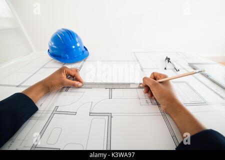 Close-up Of A Person's Hand Using Pencil To Draw Blueprint Stock Photo
