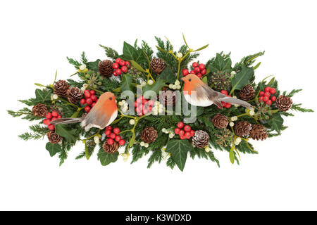 Winter greenery with robin decorations, holly, ivy, mistletoe, fir and pine cones on white background. Stock Photo