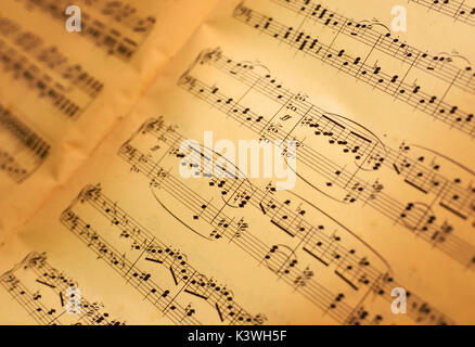 Old music sheets background with warm light. Stock Photo