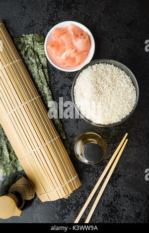 Sushi ingredients, nori seaweed on makisu bamboo mat for rolling, fresh raw  salmon, raw sushi rice, soy sauce and chopsticks on the side Stock Photo -  Alamy