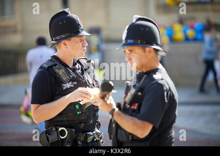 Working in uniform policemen eating at Bolton Food and Drink Festival Lancashire Stock Photo