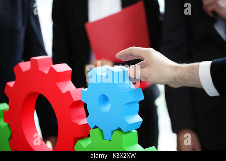 Business people assembling cogwheels, teamwork concept Stock Photo