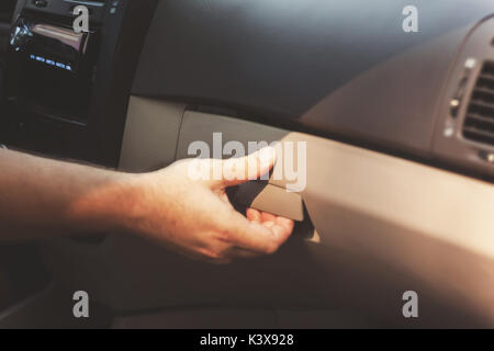 Male hand opens the glove compartment in the car, retro toningю. Stock Photo